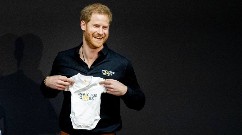 Harry holding Archie's Invictus Games onesies