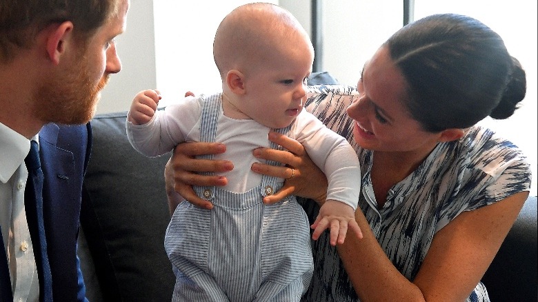 Baby Archie in H&M Dungarees and Bodysuit with Prince Harry and Meghan Markle in Africa