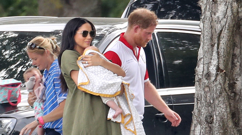 Baby Archie looking around while being held by Meghan