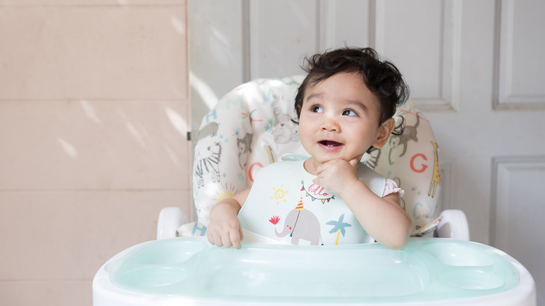 baby smiling in highchair