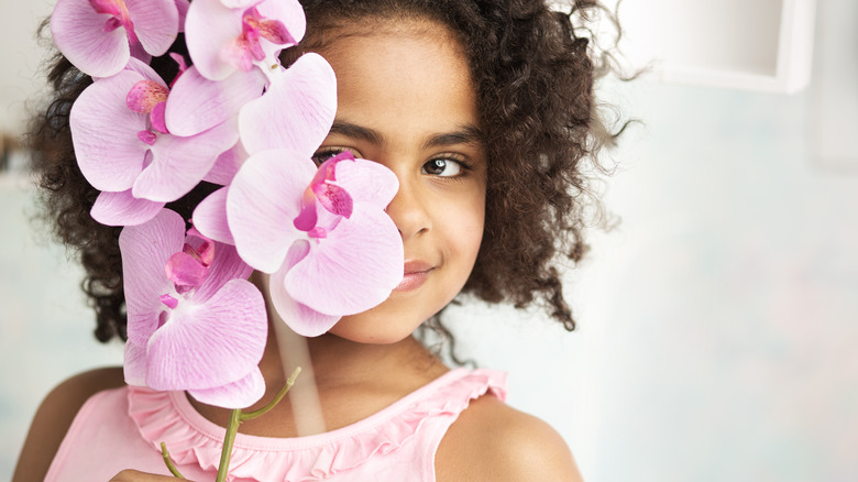 Little girl holding orchid