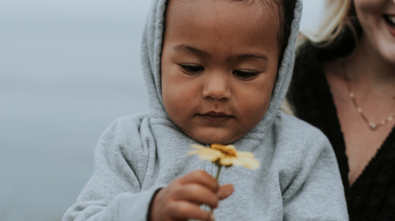 Baby holding flower