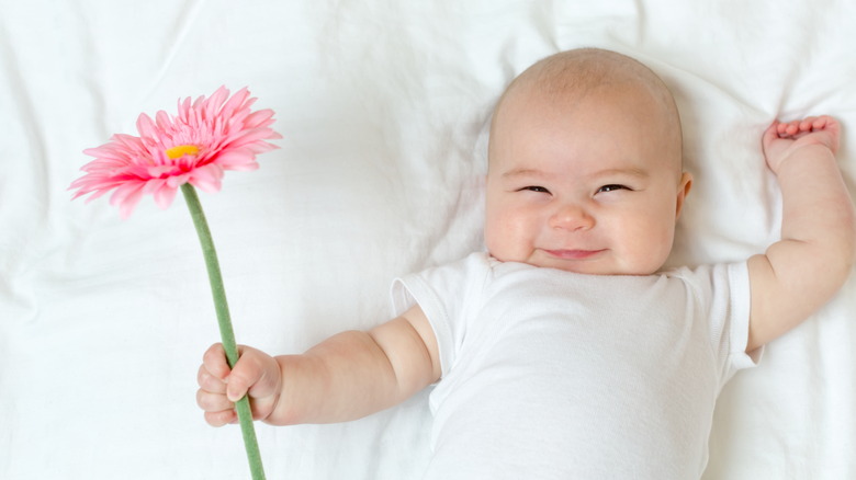 Baby holding a daisy