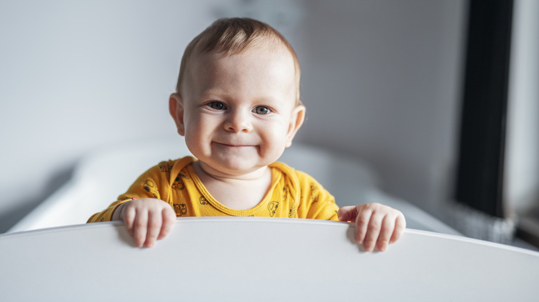 Grinning baby in a crib