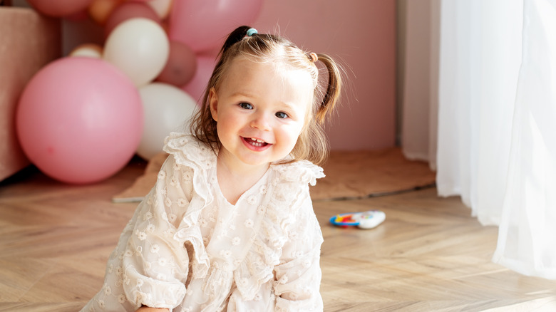 Happy baby girl with balloons