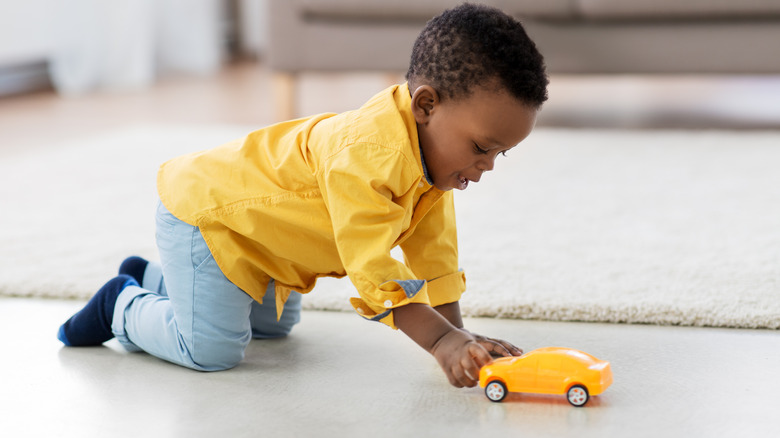 Baby boy playing with a car