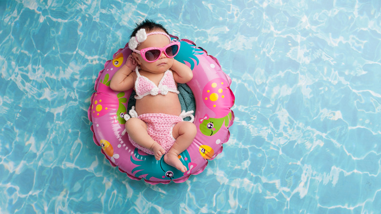 baby lounging in bathing suit and pool scene