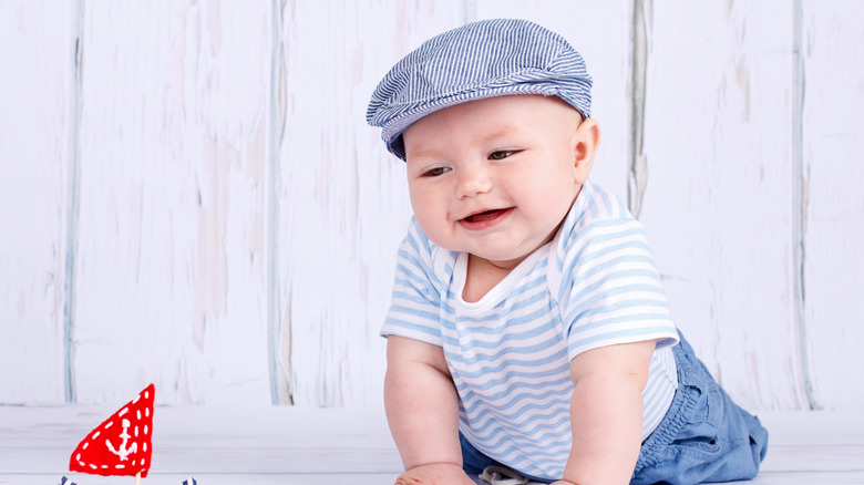 baby with a newsboy cap and striped onesie