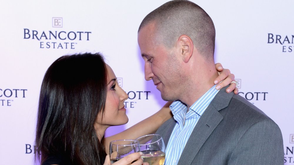 J.P. Rosenbaum and Ashley Hebert toast each other at a PR event