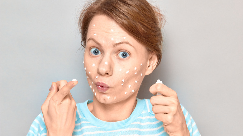 woman applying toothpaste to face