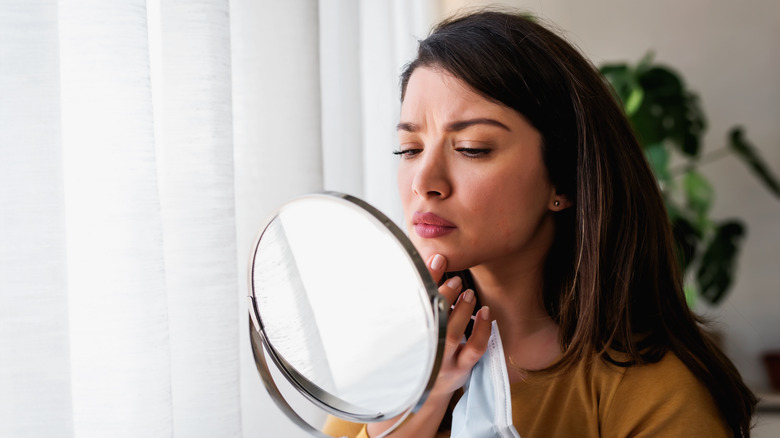 woman looking into mirror