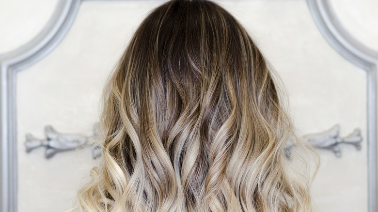 A woman showing her balayage hair highlights