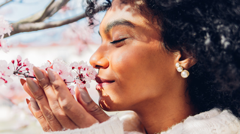 Woman smelling tree blossoms