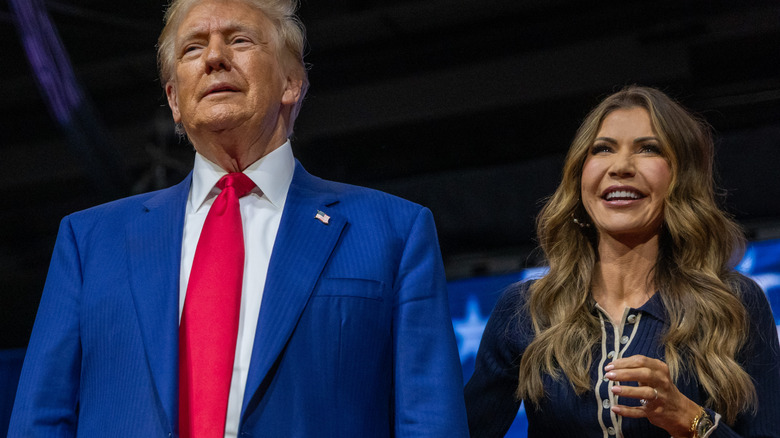 Donald Trump standing with Kristi Noem