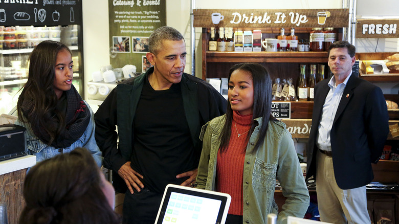 Malia and Sasha Obama at a market with their father, Barack Obama