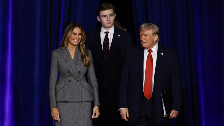 Donald, Melania, and Barron Trump smiling on stage