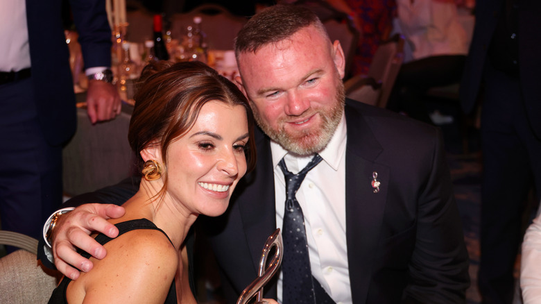 Coleen and Wayen Rooney sitting together at a dinner event