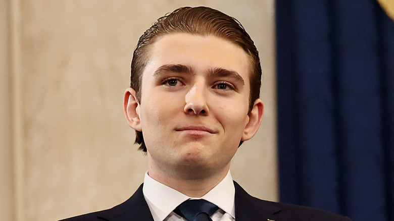 Barron Trump smiling and looking up right