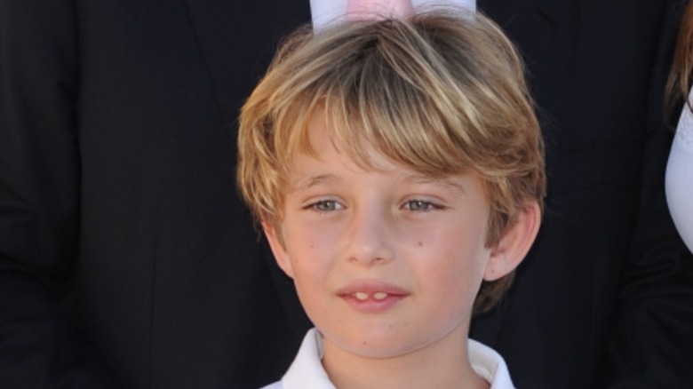 School-age Barron Trump posing at an event with his parents