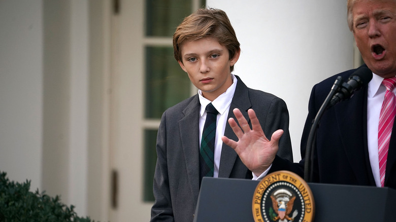 A young Barron Trump stands with president Donald Trump