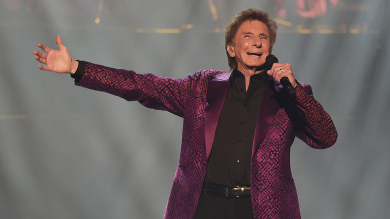 Barry Manilow singing with arm outstretched