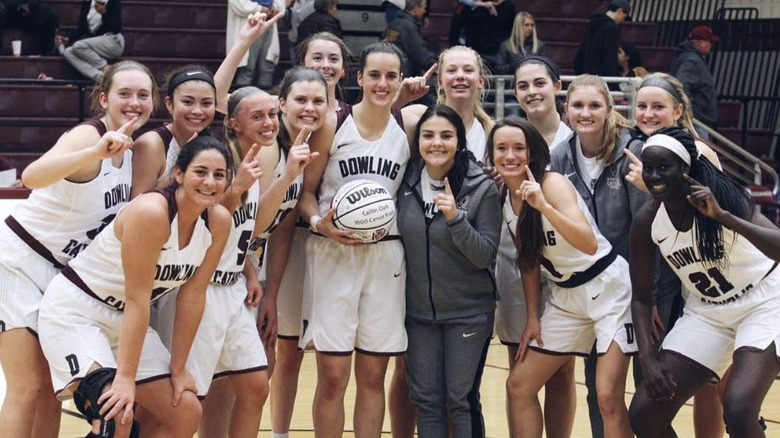 Caitlin Clark smiling with her basketball teammates