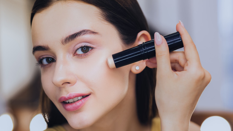 Woman applying stick foundation