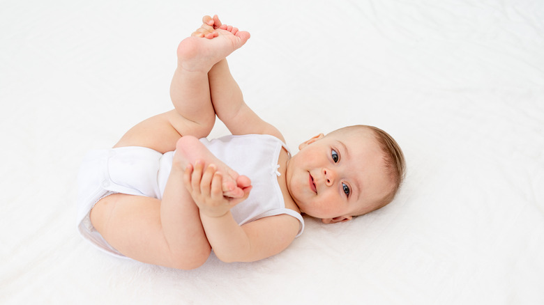 A baby playing in their crib