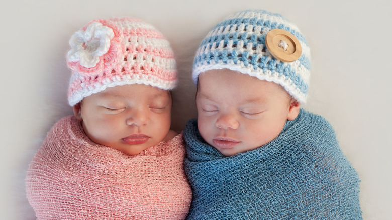 Newborn twins wearing crochet hats