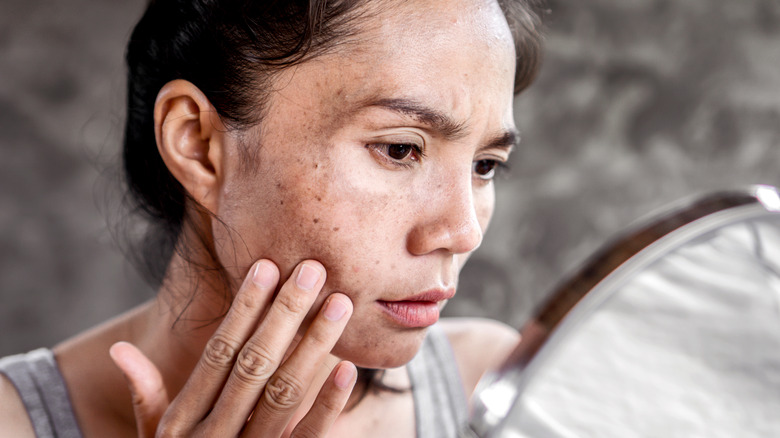 Woman examining her skin