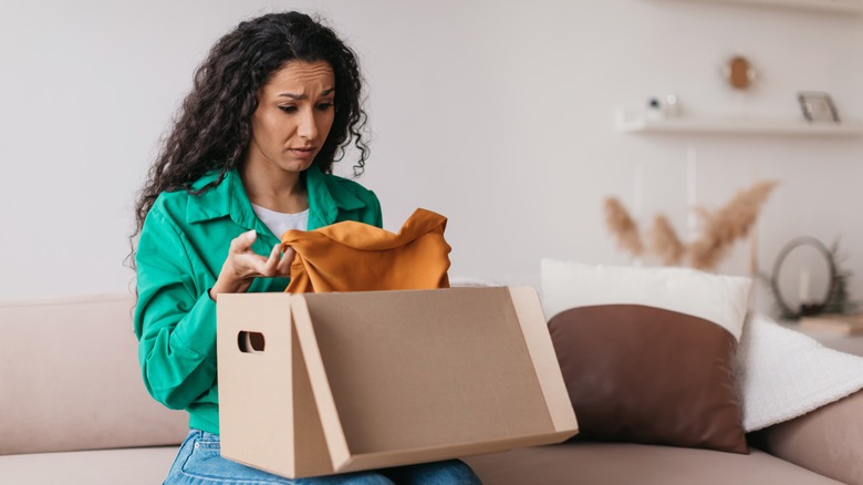 Woman looks displeased with a piece of clothing