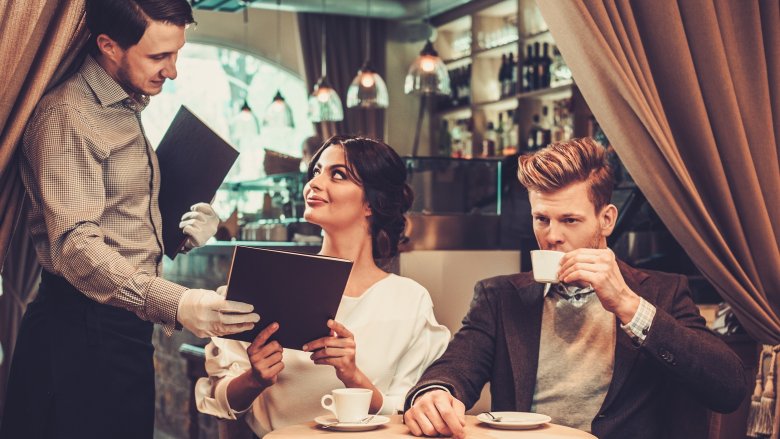 couple on date at restaurant, man ignoring waiter