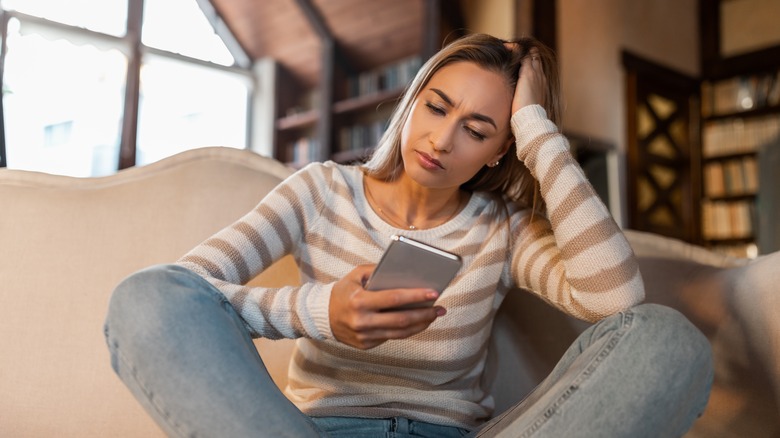 Frustrated woman looking at phone