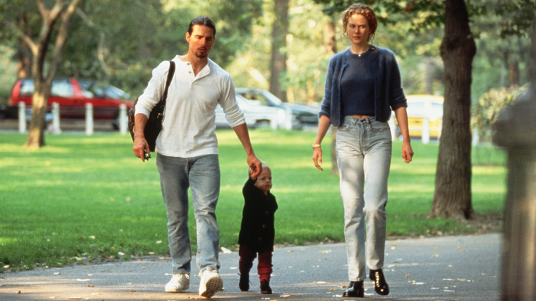 Tom Cruise holding Bella Cruise's hand walking with Nicole Kidman through park