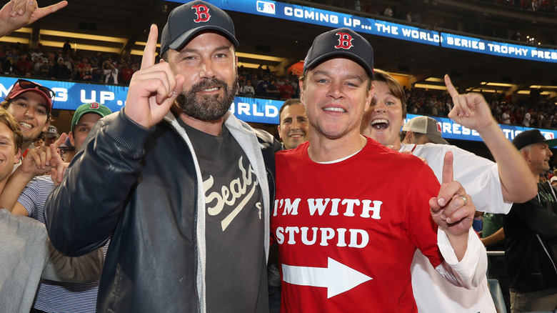 Ben Affleck and Matt Damon posing for photos at a game