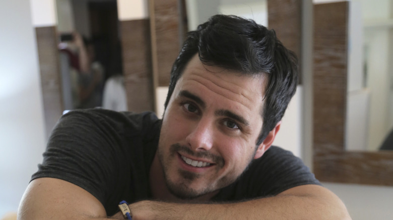 Ben Higgins smiling at camera with arms folded