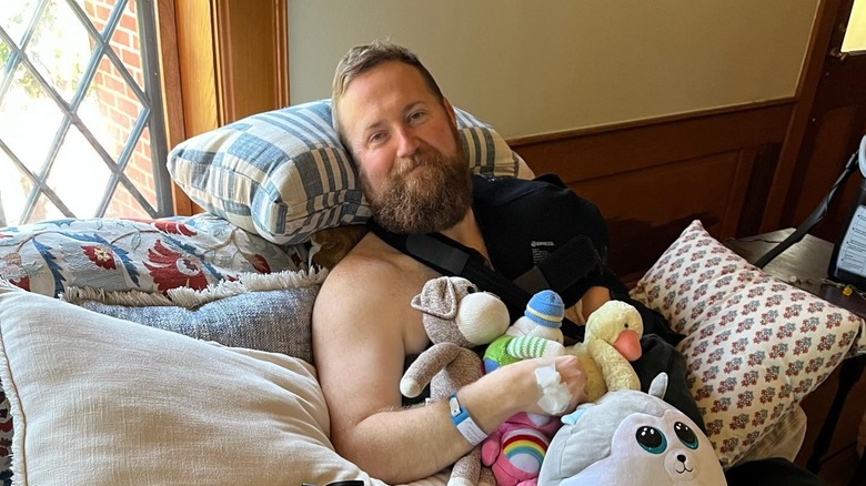 Ben recovers on the couch amid stuffed animals