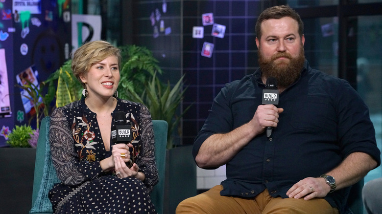 Erin and Ben Napier sitting, holding microphones