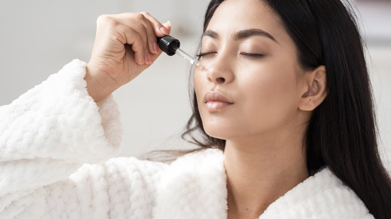 Woman applying oil to skin