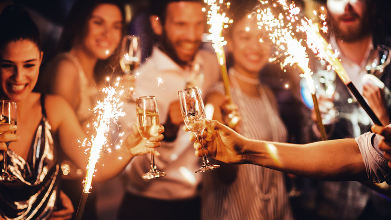 Guests toasting champagne and holding sparklers 