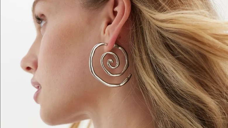 Model wearing Urban Outfitters silver spiral earrings 