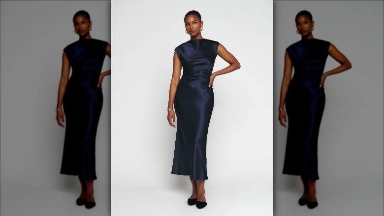 Reformation model wears navy silk gown