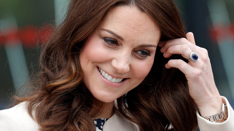 Kate Middleton smiling touching her hair