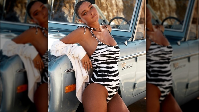 Model wearing zebra-print one-piece swimsuit