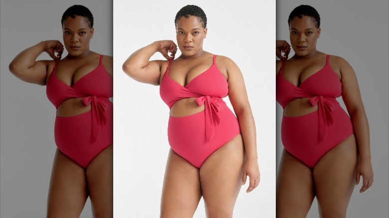 Black model wearing a pink swimsuit