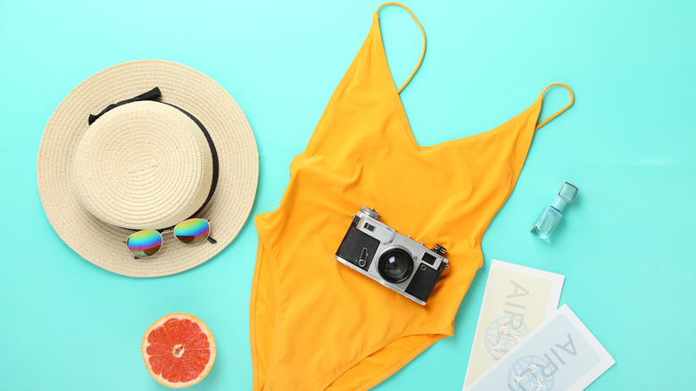 Summer hat, yellow swimsuit, and camera