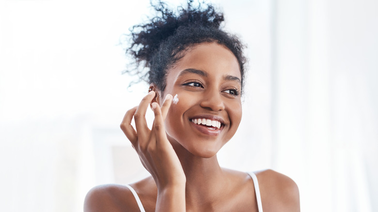 Woman using hyaluronic acid moisturizer 