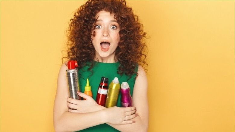 woman holding various hair products