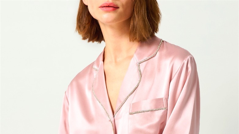 Model wearing pink silk pajamas with rhinestones