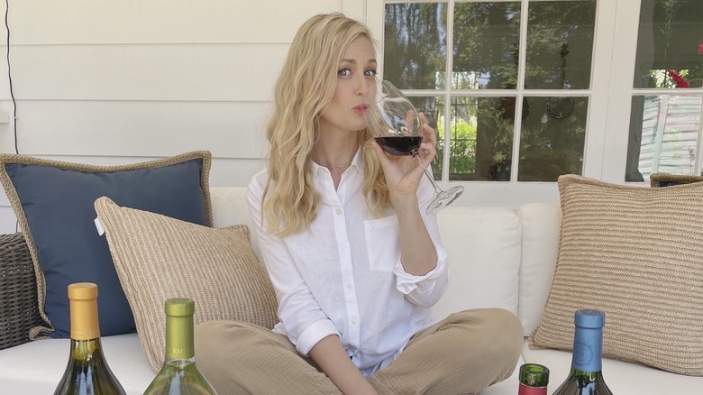 Beth Behrs drinking a glass of wine